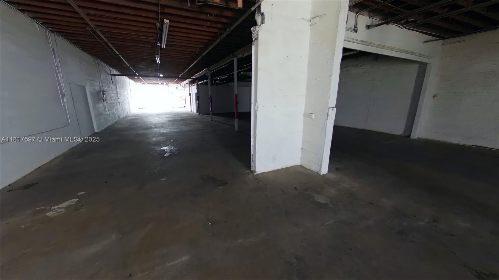 This is an empty, industrial-style warehouse space with concrete floors and exposed ceiling joists — 1083 E 24th St, Hialeah FL 33013, HIALEAH, FL