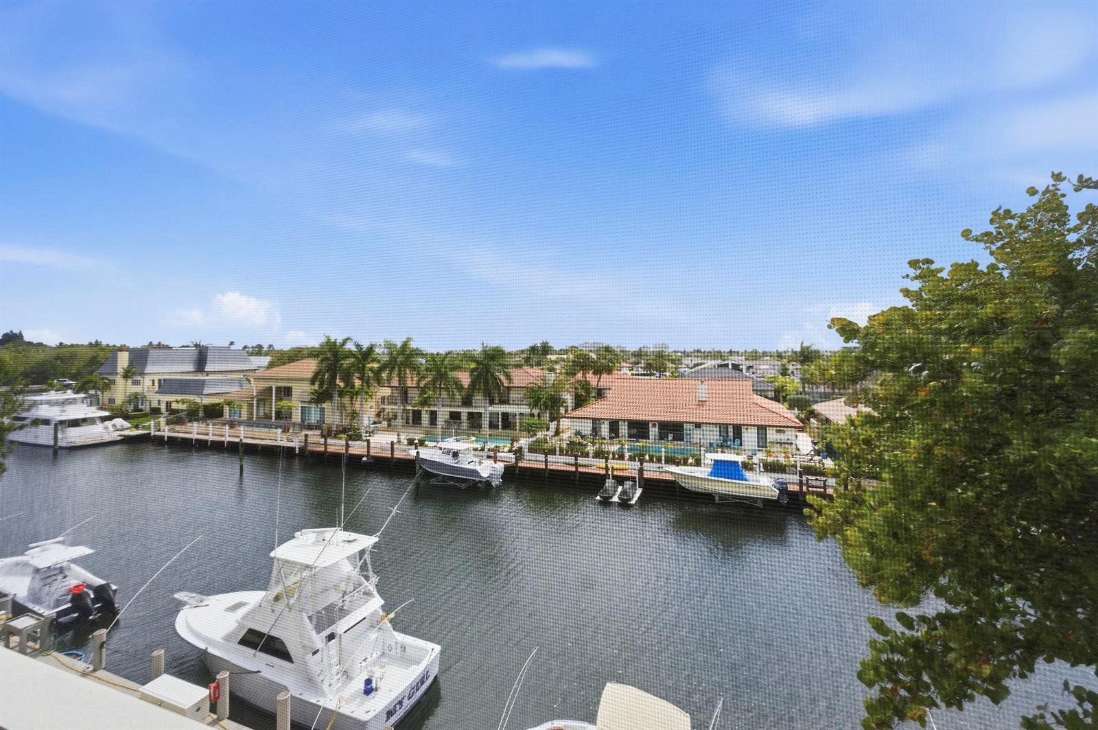 An elevated view of a canal with several docked boats and waterfront houses — 3000 NE 48th Court # 406, Lighthouse Point FL 33064, LIGHTHOUSE POINT, FL