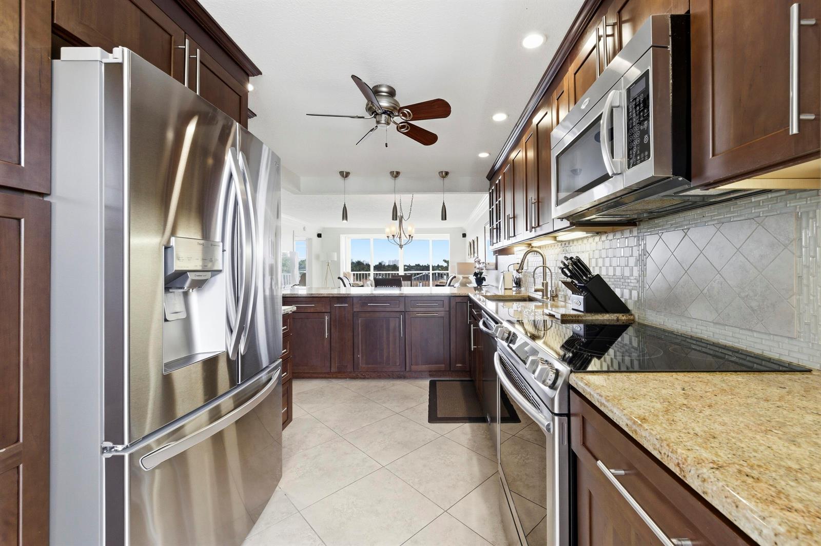 A kitchen with dark wood cabinets, stainless steel appliances, granite countertops, and tile flooring — 3000 NE 48th Court # 406, Lighthouse Point FL 33064, LIGHTHOUSE POINT, FL