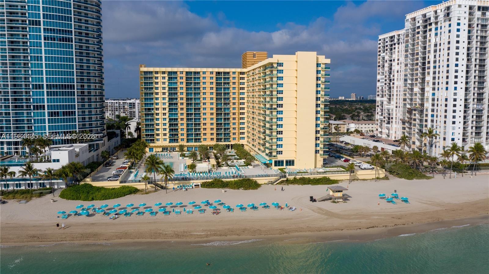 An aerial view shows a yellow beachfront hotel flanked by two tall residential towers — 2501 S Ocean Dr # 429, Hollywood FL 33019, HOLLYWOOD, FL