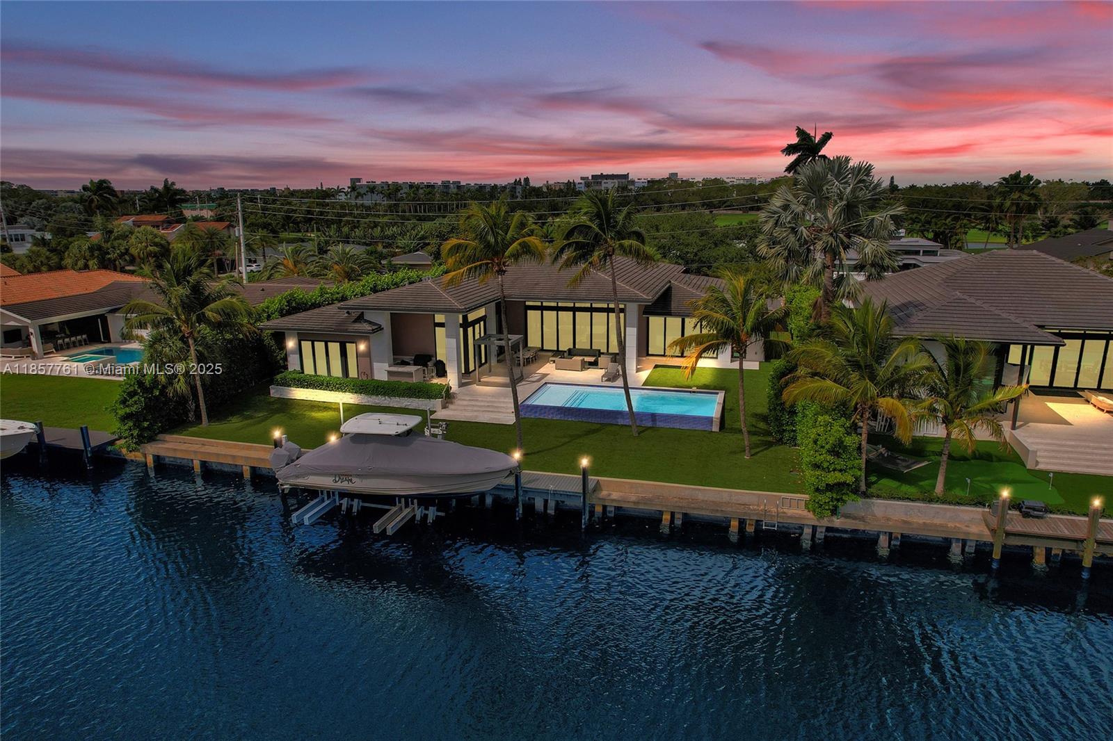 An aerial view of a waterfront house with a swimming pool, boat dock, and palm trees — 1651 Diplomat Pkwy, Hallandale Beach FL 33009, HALLANDALE BEACH, FL