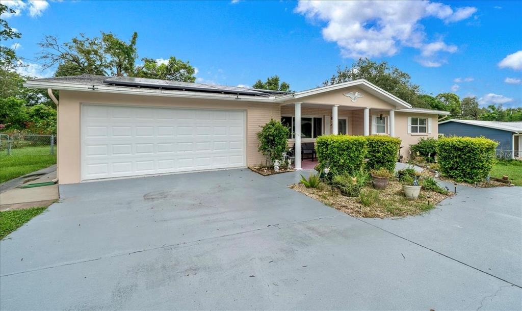A single-story house with a two-car garage, a covered front porch, and solar panels — 66 S DESOTO STREET, BEVERLY HILLS, FL