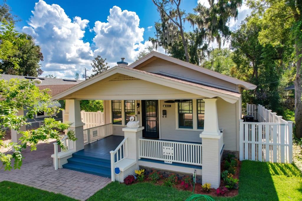 A single-story house with a front porch, white railings, and a brick-paved driveway — 806 JOHNSON AVENUE, LAKELAND, FL