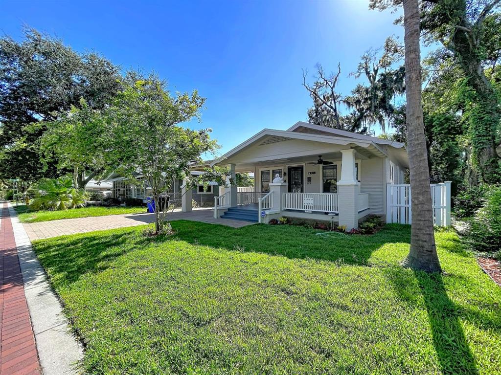 A single-story bungalow with a front porch and a paved driveway sits on a lawn — 806 JOHNSON AVENUE, LAKELAND, FL
