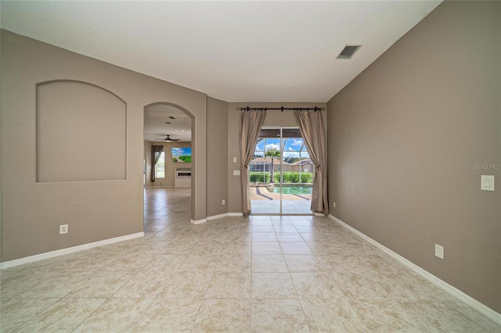 A tiled room features a recessed wall niche, an arched doorway, and sliding glass doors — 12626 30TH STREET CIRCLE E, PARRISH, FL