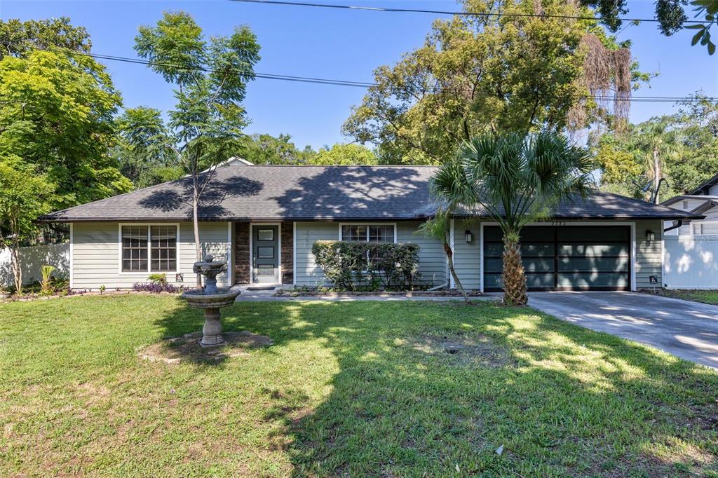 A single-story house with light green siding, a dark roof, and a front yard fountain — 2780 PASEO AVENUE, ORLANDO, FL