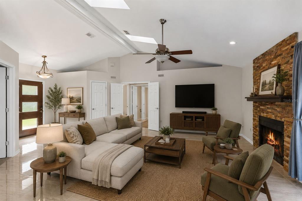 A living room features a stone fireplace, a sectional sofa, and two olive green armchairs — 2780 PASEO AVENUE, ORLANDO, FL