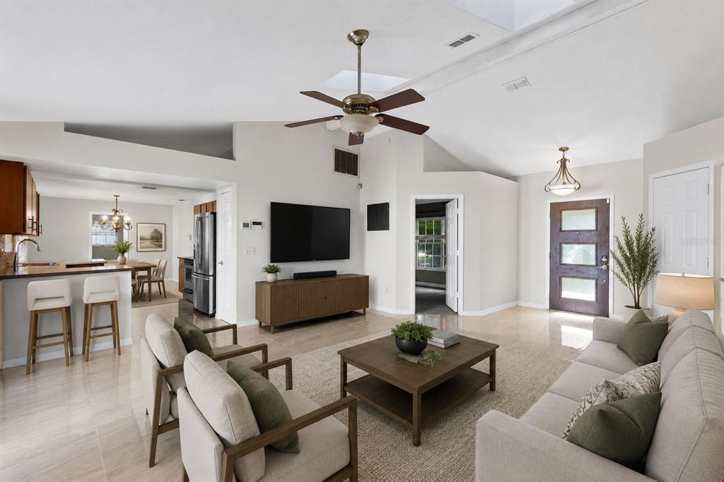 A bright living room features a vaulted ceiling, a ceiling fan, and an open kitchen — 2780 PASEO AVENUE, ORLANDO, FL