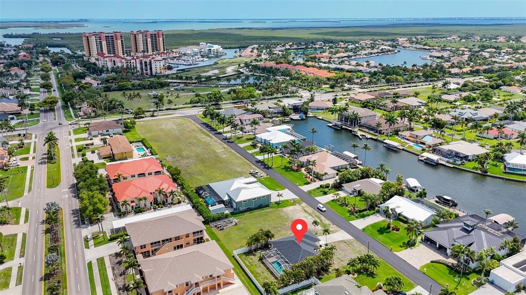 An aerial view shows a residential neighborhood with a canal and a marked house — 5333 SW 16TH PLACE, CAPE CORAL, FL