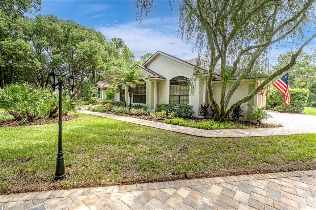 A single-story house with a paved walkway, a lamp post, and an American flag — 5328 MACOSO COURT, NEW PORT RICHEY, FL