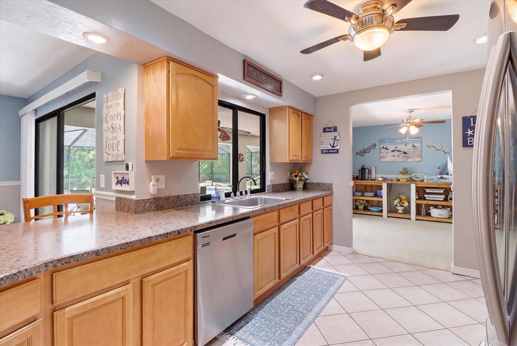 A kitchen with light wood cabinets, granite countertops, stainless steel appliances, and tile flooring — 12 ASTERS COURT, HOMOSASSA, FL