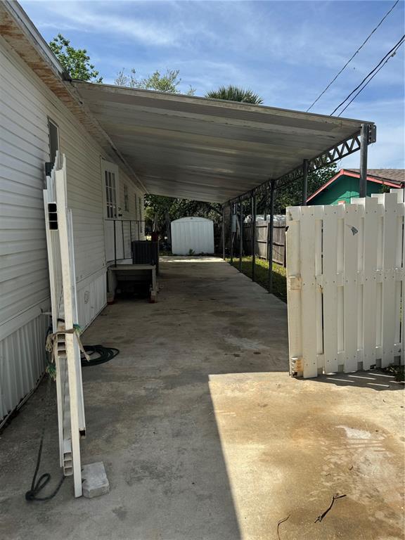 A concrete driveway with a metal carport cover sits beside a white mobile home — 5406 SYDNEY STREET, PORT ORANGE, FL
