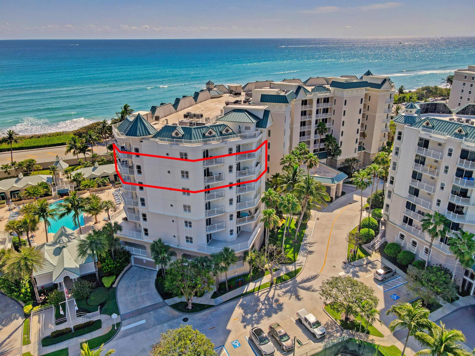 An aerial view of a multi-story beachfront condominium building with a red outline highlighting balconies — 221 Ocean Grande Boulevard # 701, Jupiter FL 33477, JUPITER, FL
