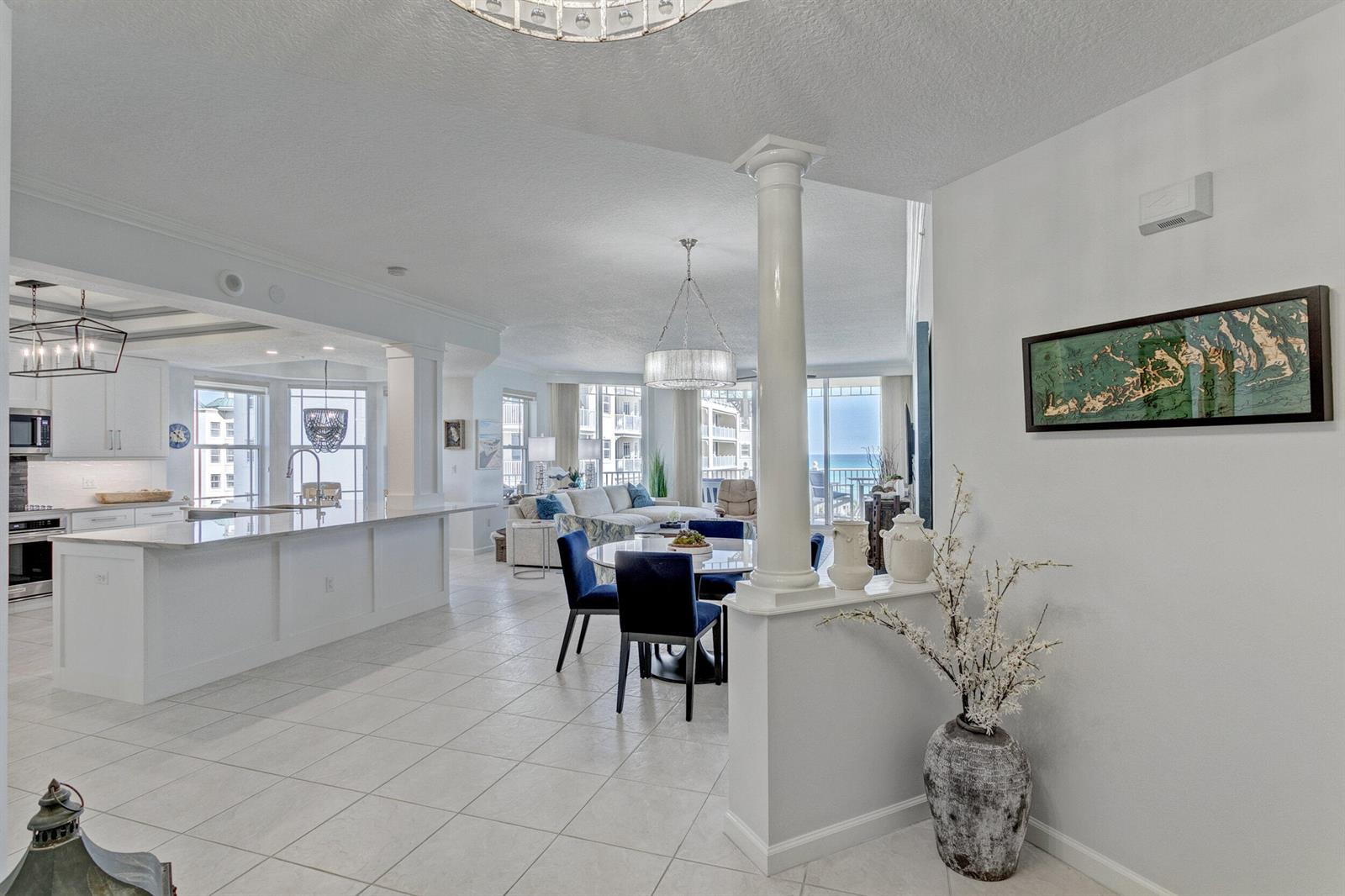 An open-concept living area features a white kitchen, dining space, and ocean views — 221 Ocean Grande Boulevard # 701, Jupiter FL 33477, JUPITER, FL