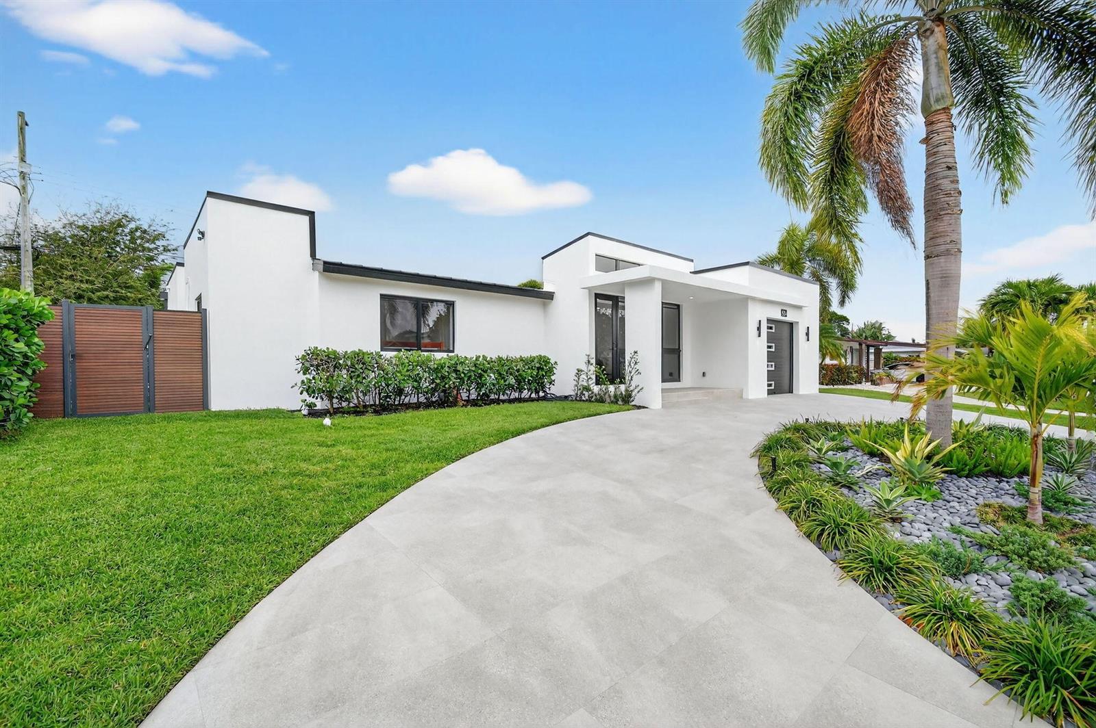 A modern white single-story house features a curved concrete driveway and a palm tree — 504 Flotilla Road, North Palm Beach FL 33408, NORTH PALM BEACH, FL