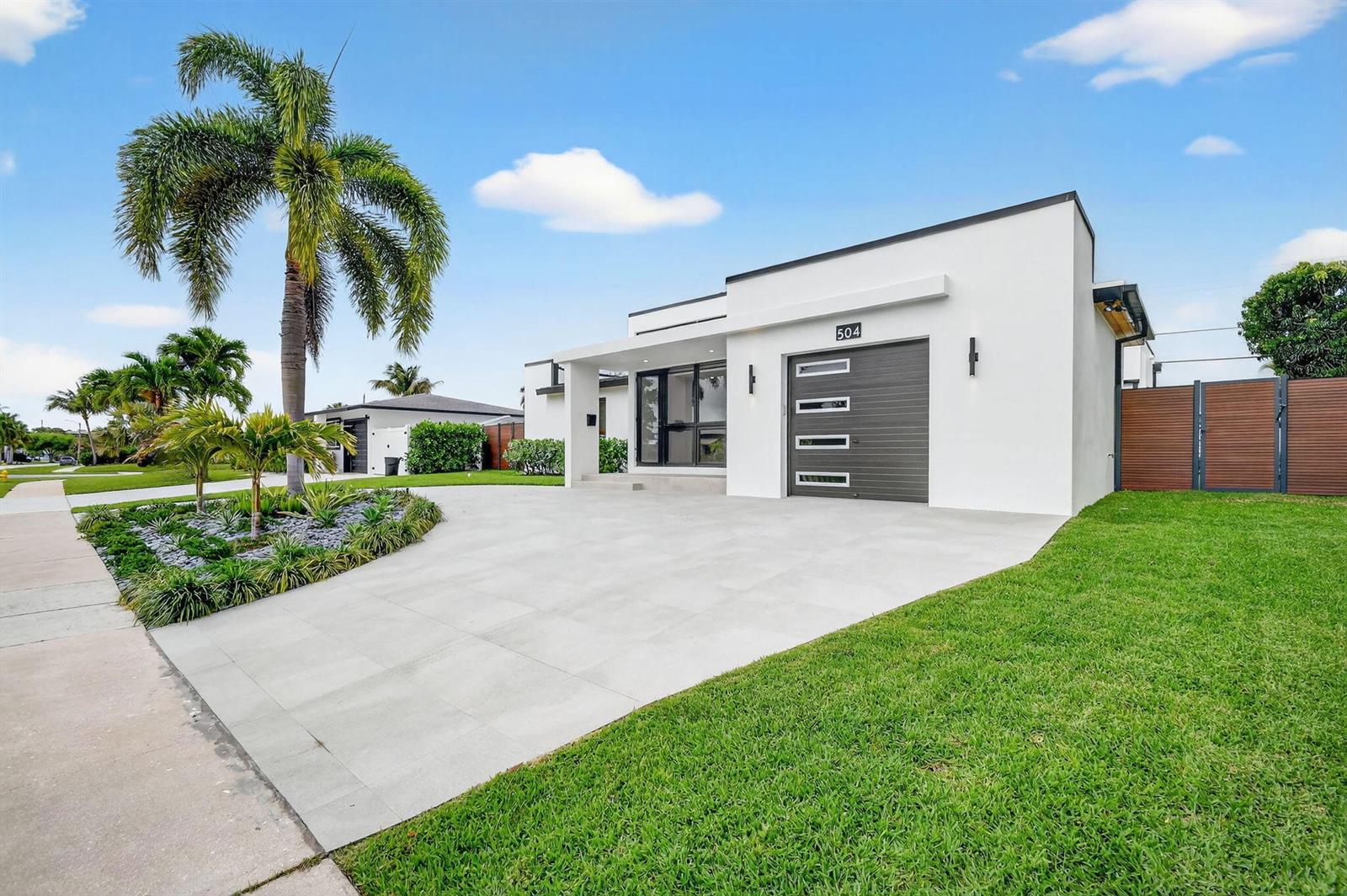 A modern white single-story house with a gray garage door and a palm tree — 504 Flotilla Road, North Palm Beach FL 33408, NORTH PALM BEACH, FL