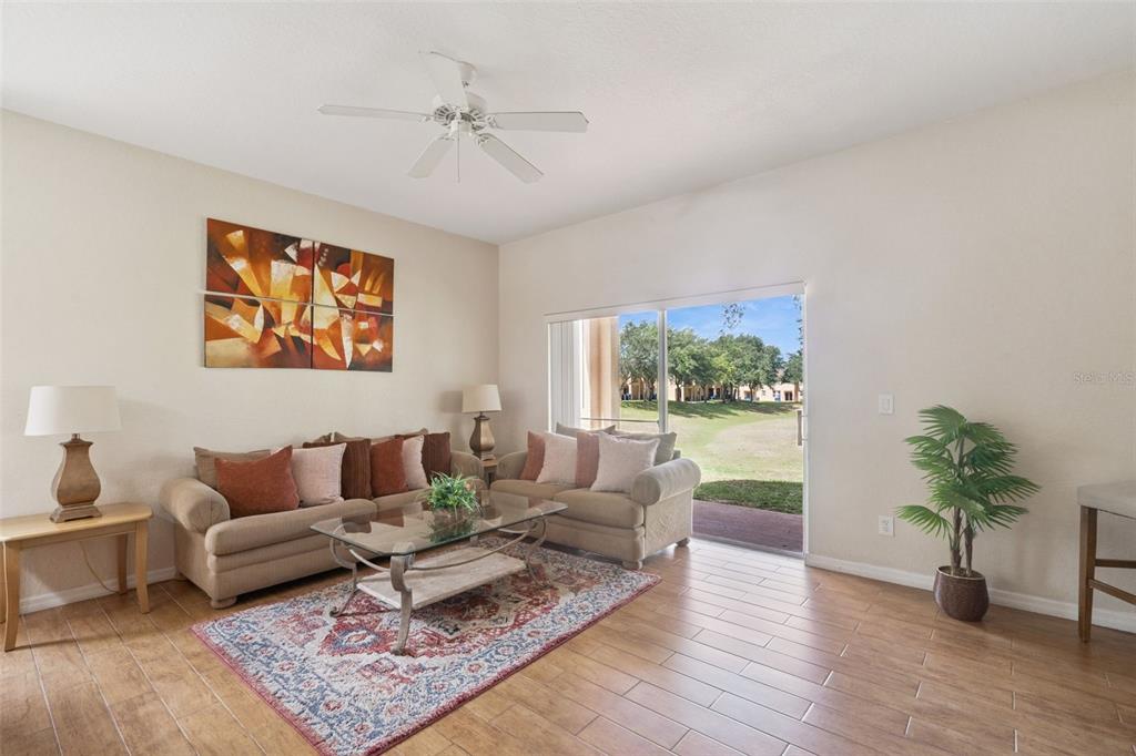 A living room with tile floors, two sofas, a coffee table, and a sliding glass door — 2205 CALABRIA AVENUE, DAVENPORT, FL