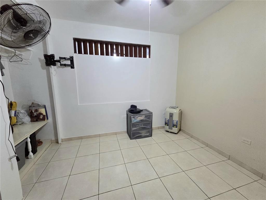 A room with white walls, tiled flooring, a ceiling fan, and a small storage unit — 173 KM 15.8, CIDRA, PR