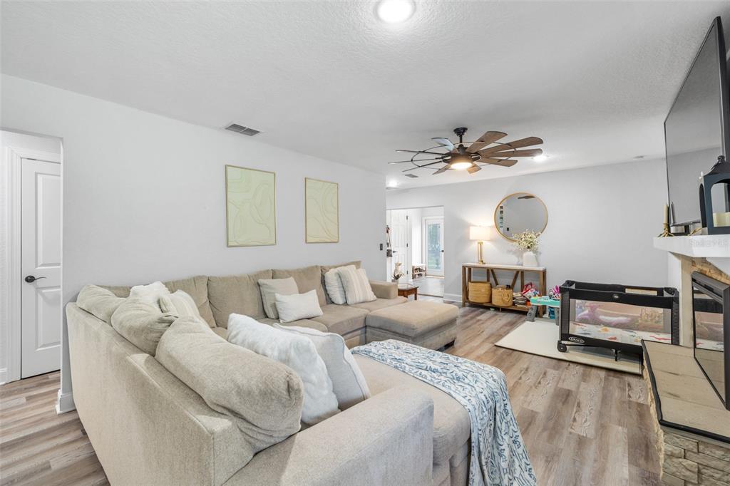A living room features a large sectional sofa, a ceiling fan, and a playpen — 2118 E KEYSVILLE ROAD, LITHIA, FL