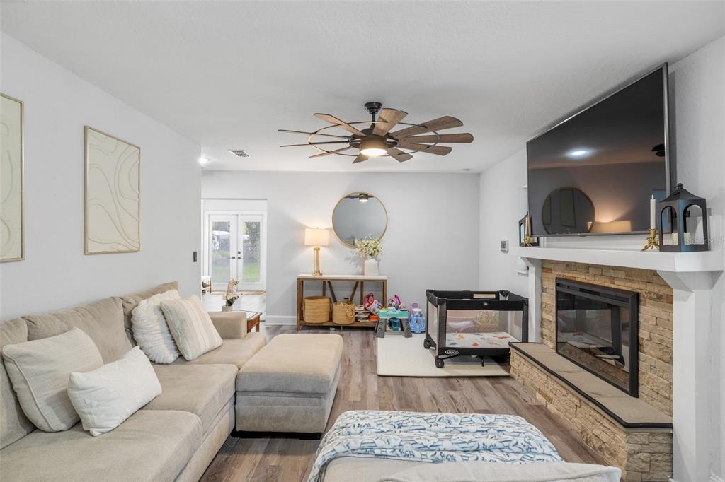 A living room features a stone fireplace, a sectional sofa, and a ceiling fan — 2118 E KEYSVILLE ROAD, LITHIA, FL
