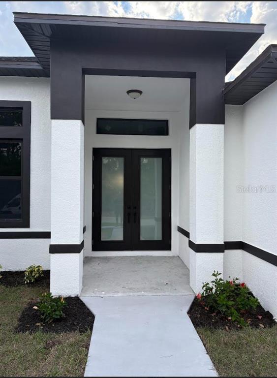 A modern home entrance features a double door with frosted glass and dark trim — 1393 RICHMAR STREET, NORTH PORT, FL
