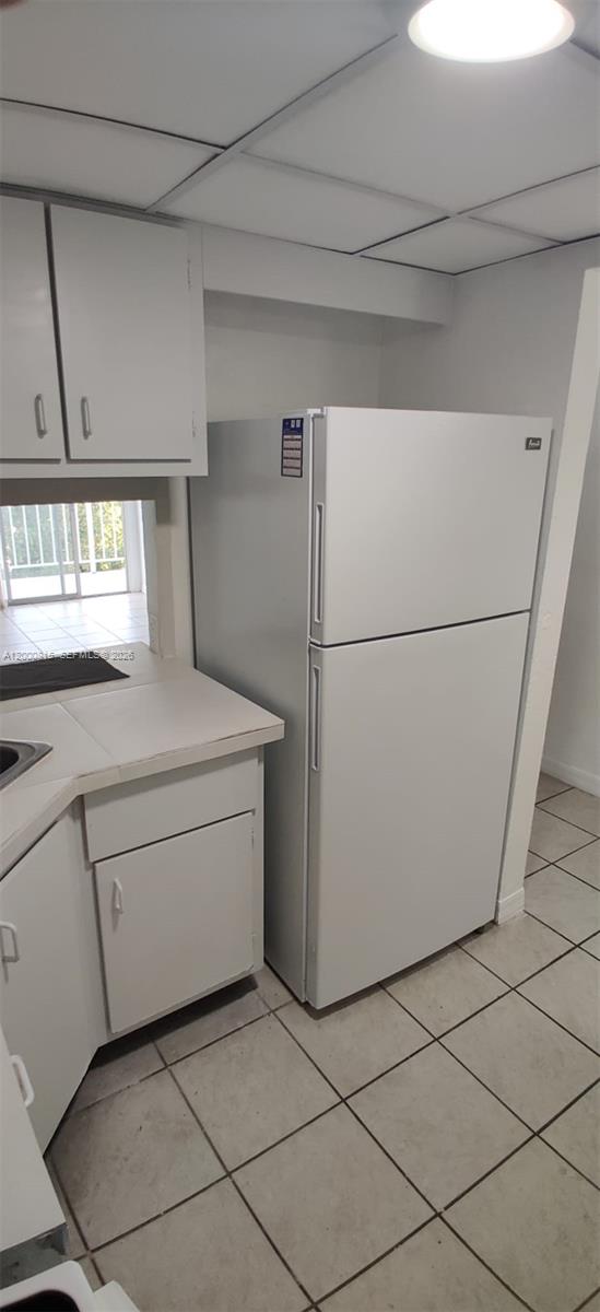 A white refrigerator stands in a kitchen with white cabinets and tiled flooring — 4550 NW 9th St # 706E, Miami FL 33126, MIAMI, FL