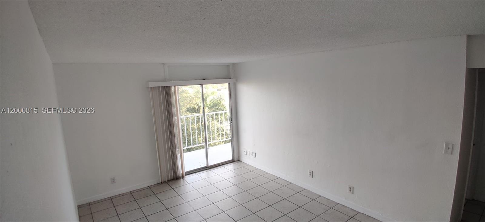 An empty room with white walls, tile flooring, and a sliding glass door to a balcony — 4550 NW 9th St # 706E, Miami FL 33126, MIAMI, FL