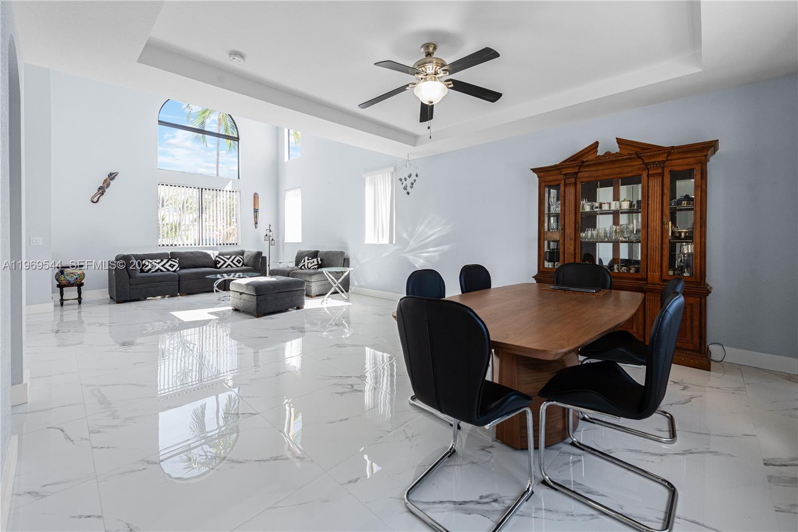 A dining area and living room with white marble floors and high ceilings — 972 NE 36th Ave, Homestead FL 33033, HOMESTEAD, FL