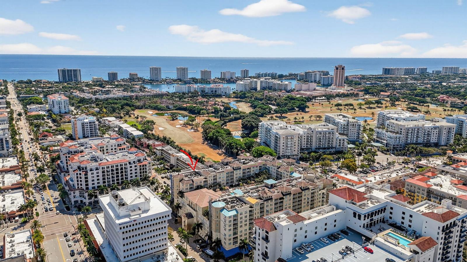 An aerial view shows a multi-story residential complex with a red arrow pointing toward it — 99 SE Mizner Boulevard # 603, Boca Raton FL 33432, BOCA RATON, FL