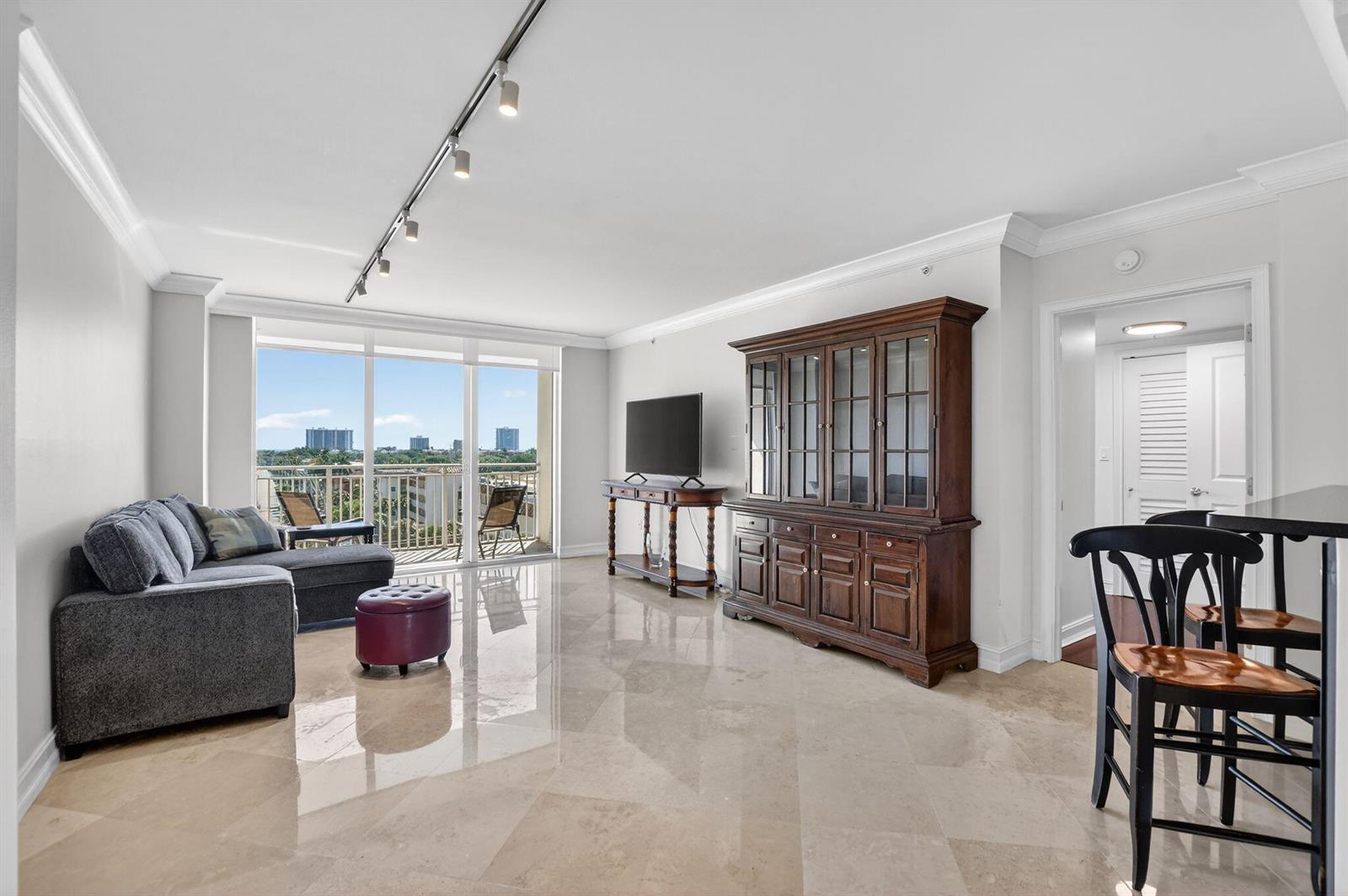 A living room features light tile floors, a grey sectional sofa, and a large hutch — 99 SE Mizner Boulevard # 603, Boca Raton FL 33432, BOCA RATON, FL