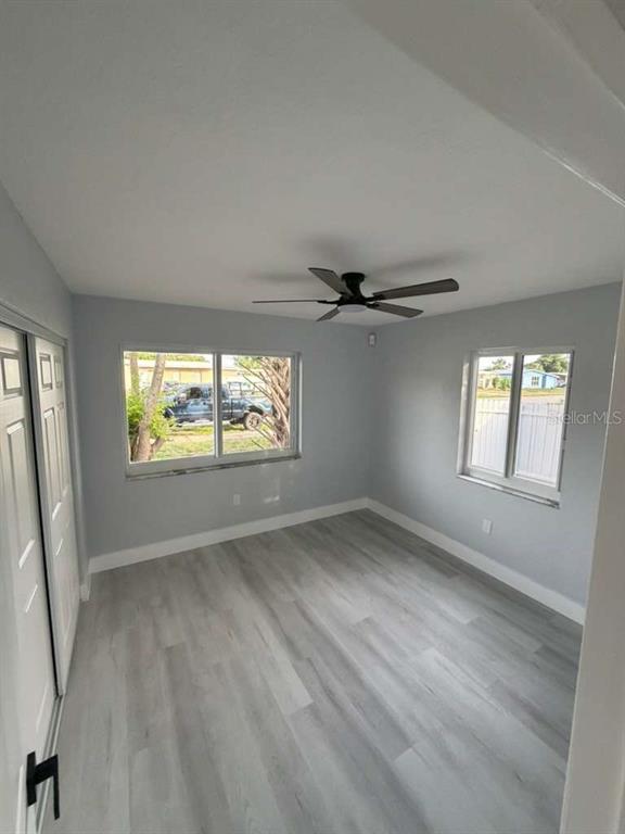 An empty bedroom with light gray walls, wood-look flooring, and a ceiling fan — 22202 BELINDA AVENUE, PORT CHARLOTTE, FL