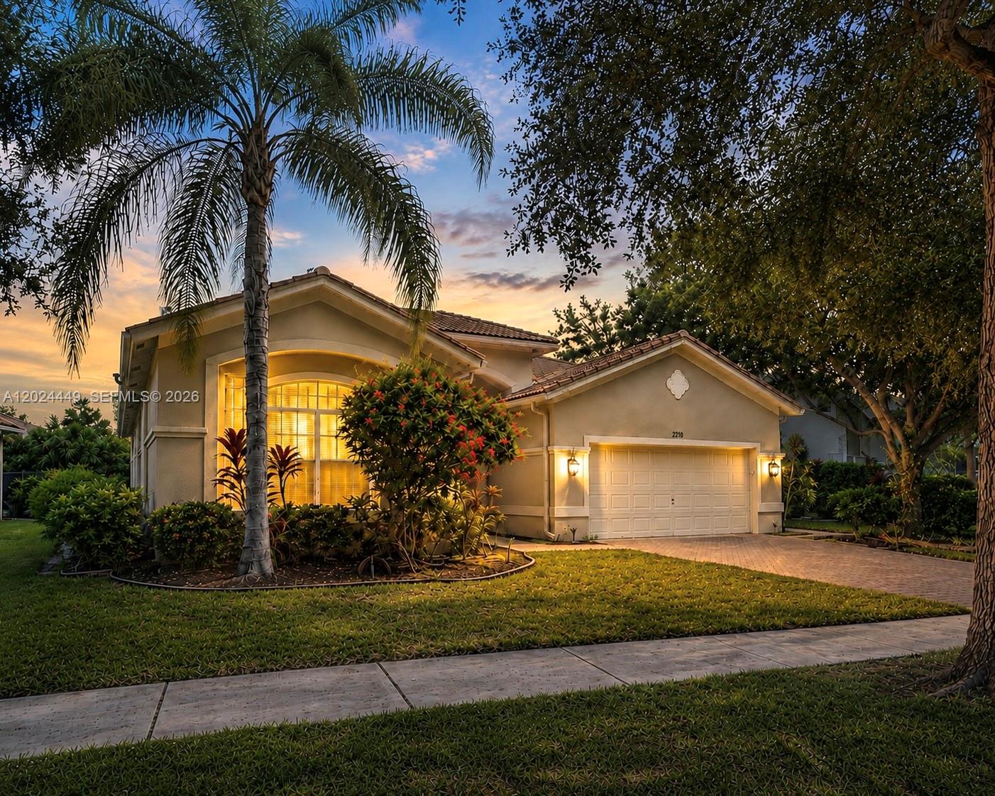 A modern kitchen features a large waterfall island, white cabinetry, and a wood-paneled base — 4486 W Whitewater Ave, Weston FL 33332, WESTON, FL