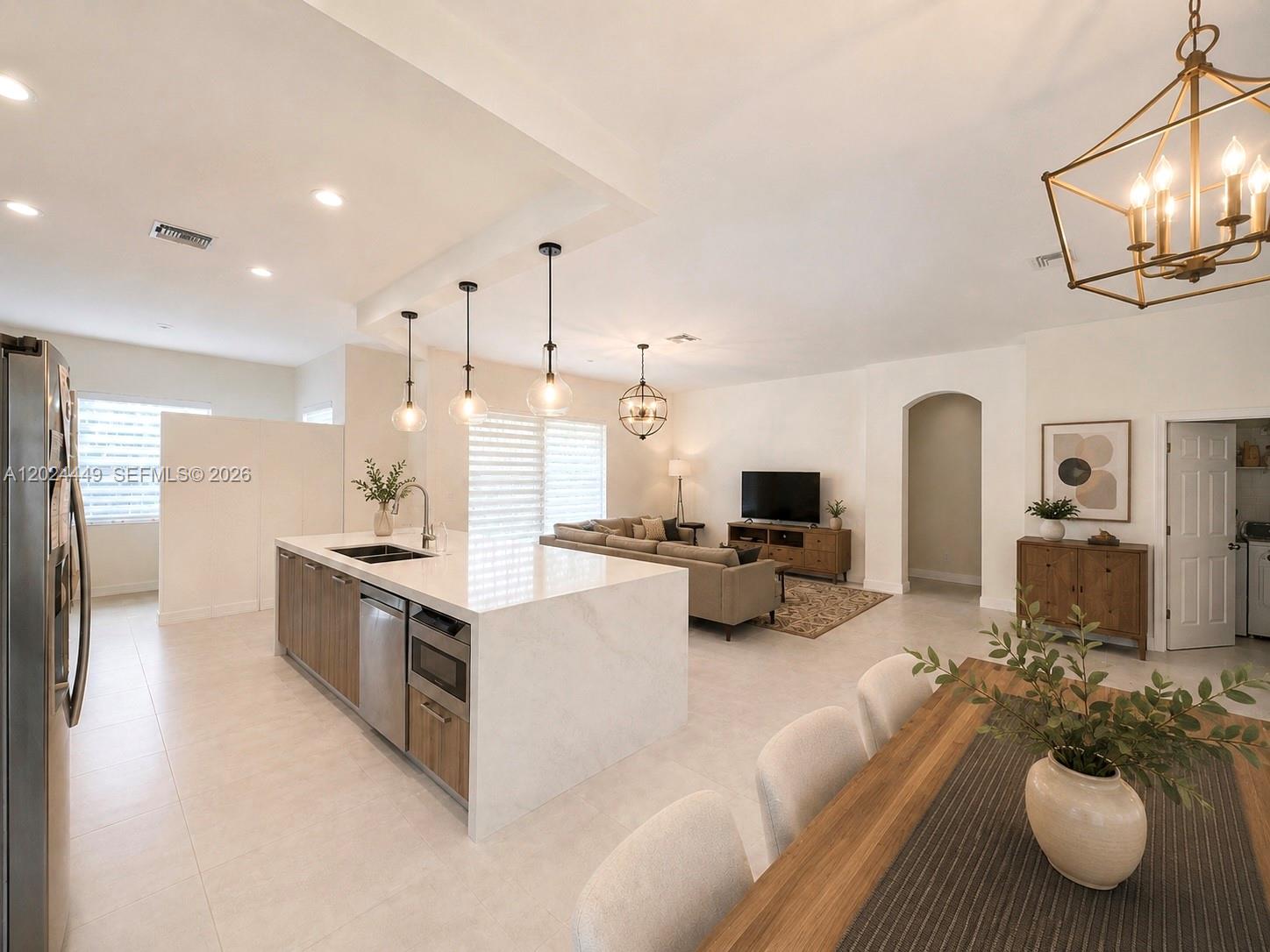 An open-concept kitchen, dining area, and living room featuring a large quartz-topped island — 4486 W Whitewater Ave, Weston FL 33332, WESTON, FL