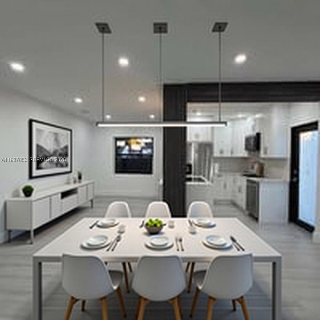 A modern dining room features a white table, six chairs, and a linear pendant light — 854 NW 76th St, Miami FL 33150, MIAMI, FL