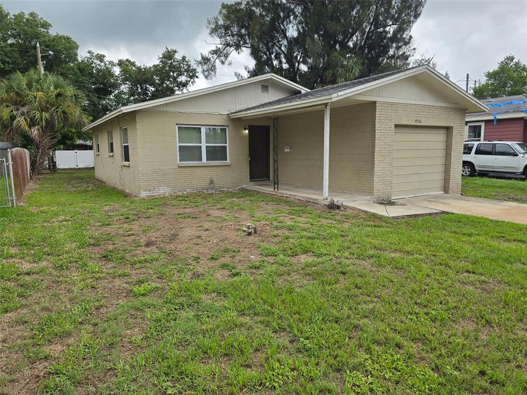 A single-story house with a tan brick exterior, a garage, and a front lawn — 4542 21ST AVENUE S, ST PETERSBURG, FL