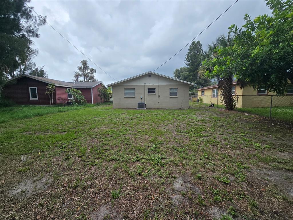 The exterior of a tan house with a large backyard and adjacent neighboring homes — 4542 21ST AVENUE S, ST PETERSBURG, FL