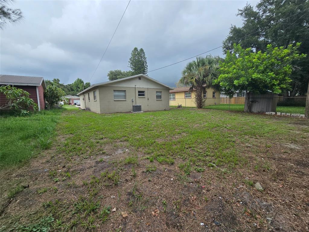 A view of the backyard and the rear exterior of a single-story tan house — 4542 21ST AVENUE S, ST PETERSBURG, FL