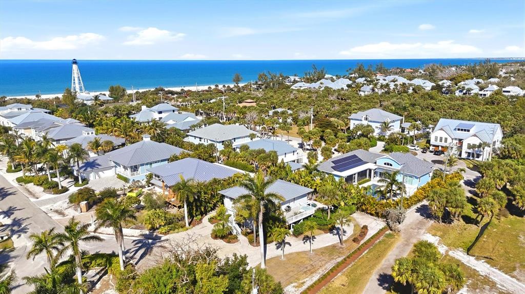 An elevated house with gray siding, a metal roof, and a white garage door — 281 SEABREEZE COURT, BOCA GRANDE, FL