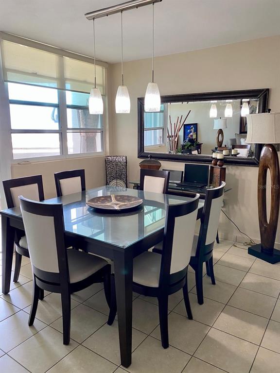 A dining room features a glass-topped table, six chairs, pendant lighting, and a large mirror — 155 CARAZO ST. CONDO. REGENCY PARK UNIT 17-C, GUAYNABO, PR