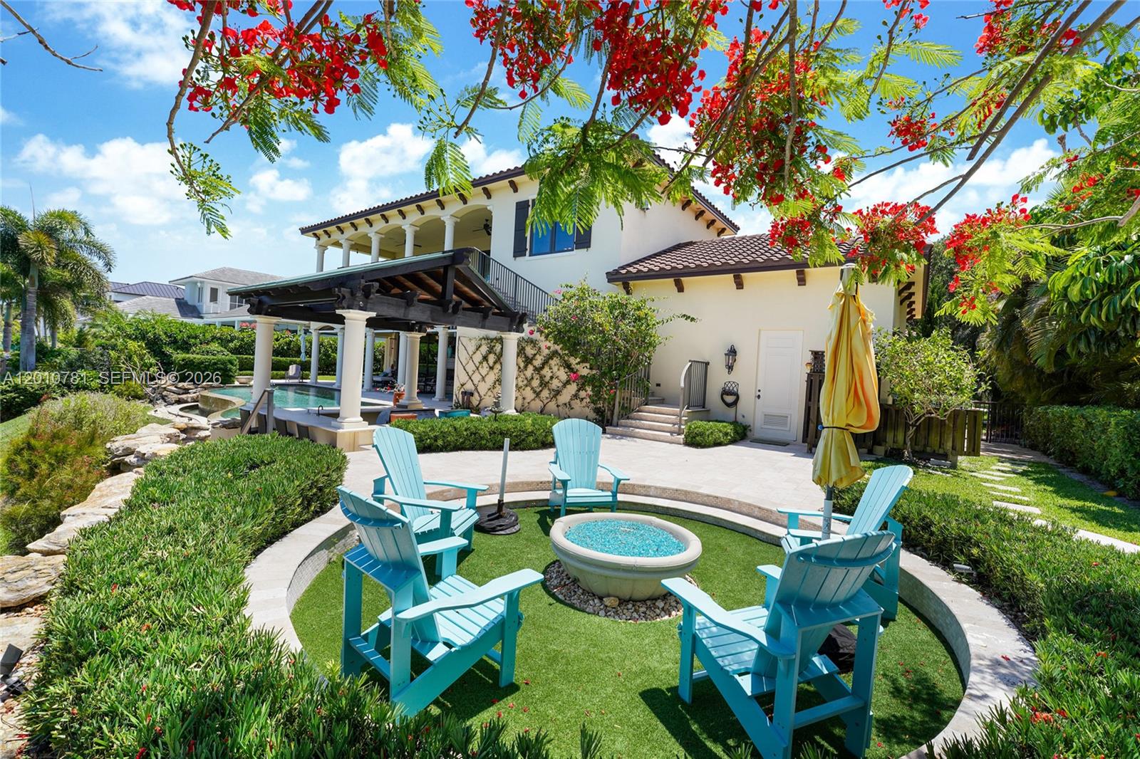 A backyard patio features a fire pit, blue Adirondack chairs, and a swimming pool area — 10433 SE Banyan Way, Jupiter FL 33469, JUPITER, FL