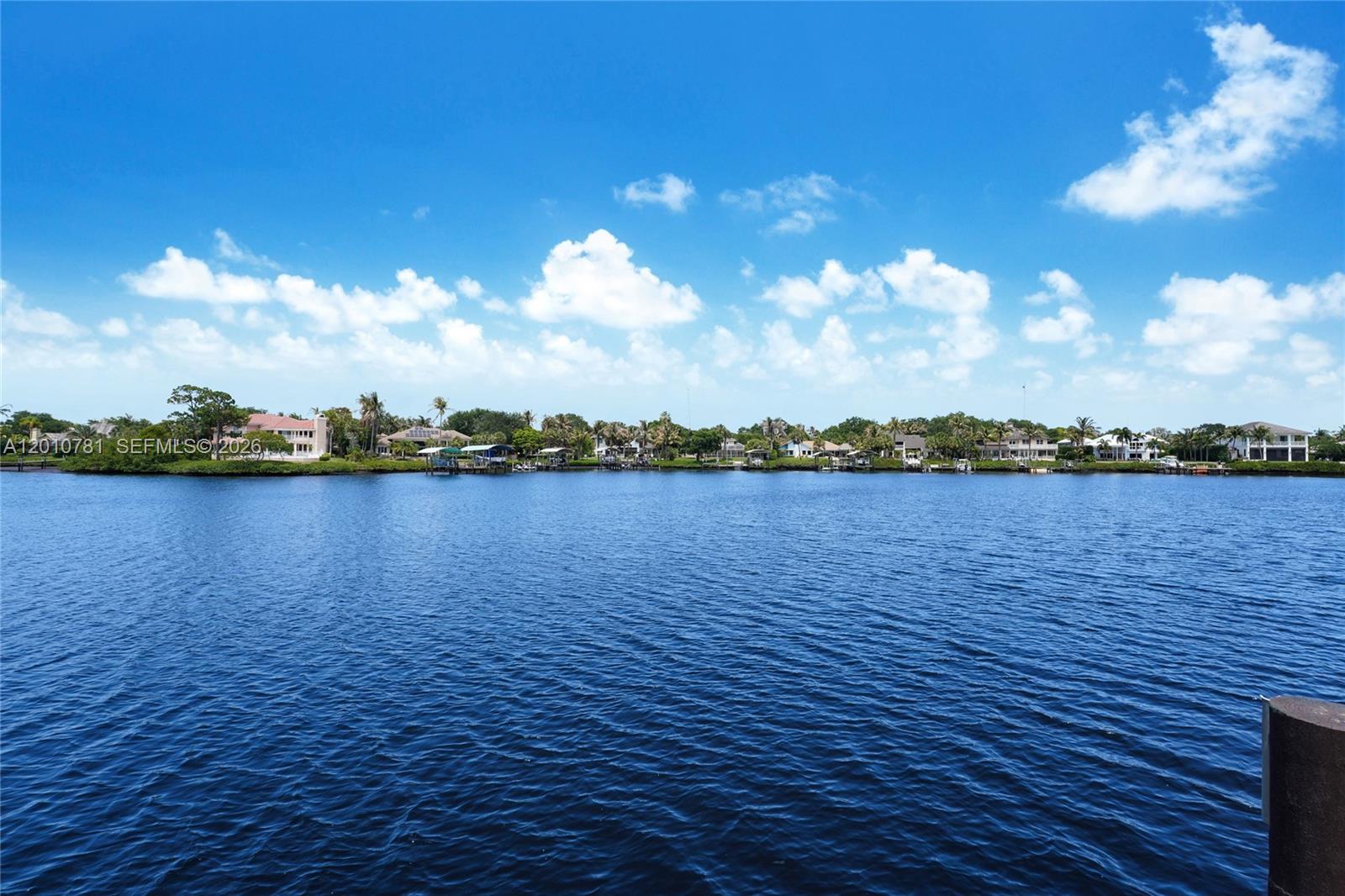 A wide view of a calm blue waterway bordered by houses and trees — 10433 SE Banyan Way, Jupiter FL 33469, JUPITER, FL