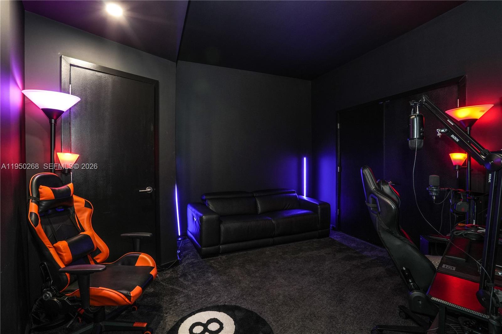 A dark gaming room features a black sofa, two gaming chairs, and colorful accent lighting — 851 NE 1st Ave # 2101, Miami FL 33132, MIAMI, FL