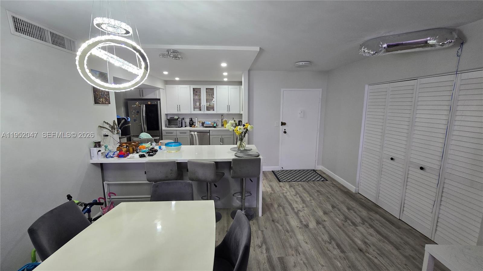 A kitchen with white cabinets and a breakfast bar overlooks a dining area — 2500 Parkview Dr # 2312, Hallandale Beach FL 33009, HALLANDALE BEACH, FL