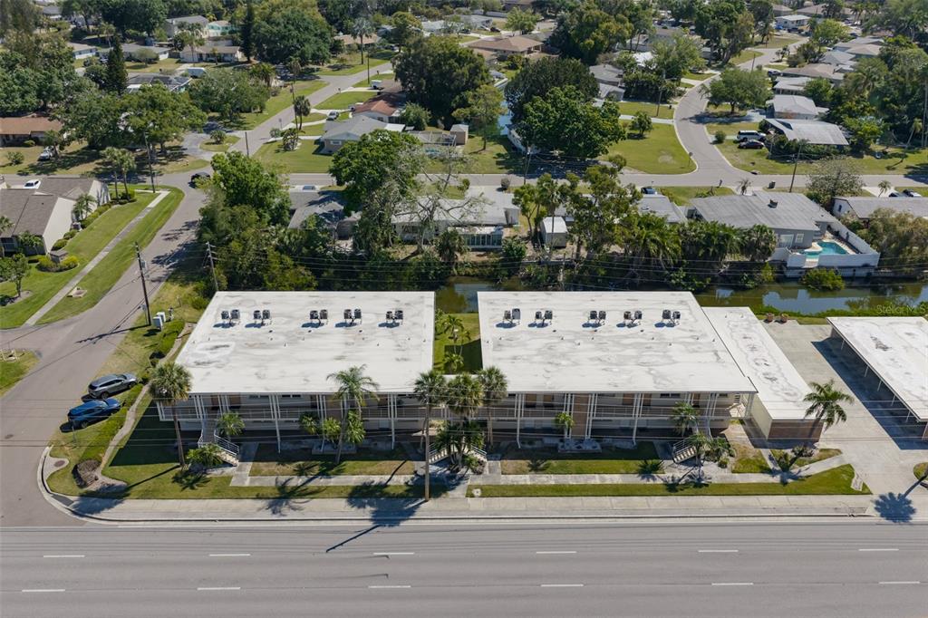 An aerial view shows two adjacent apartment buildings with flat roofs and palm trees — 4565 DUHME ROAD UNIT 106, MADEIRA BEACH, FL