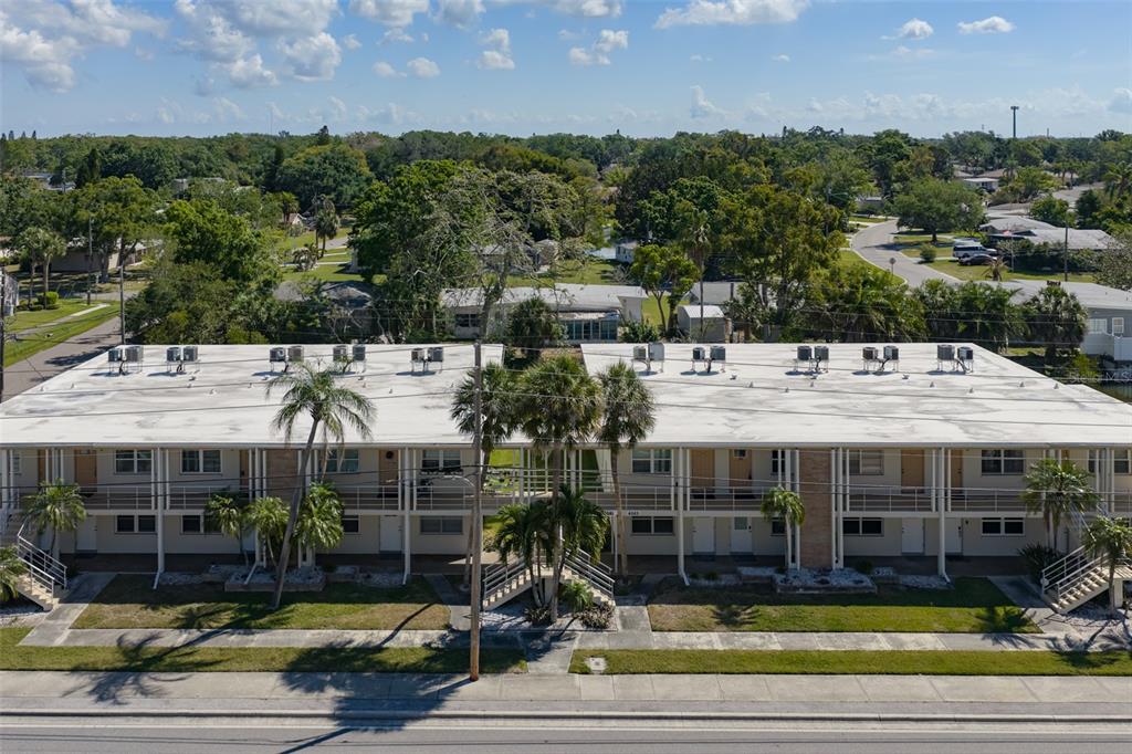 An aerial view of a two-story apartment building with a flat roof and palm trees — 4565 DUHME ROAD UNIT 106, MADEIRA BEACH, FL