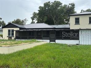 A view of the exterior of a house featuring a large screened-in porch — 912 LAKE JESSIE DRIVE, WINTER HAVEN, FL