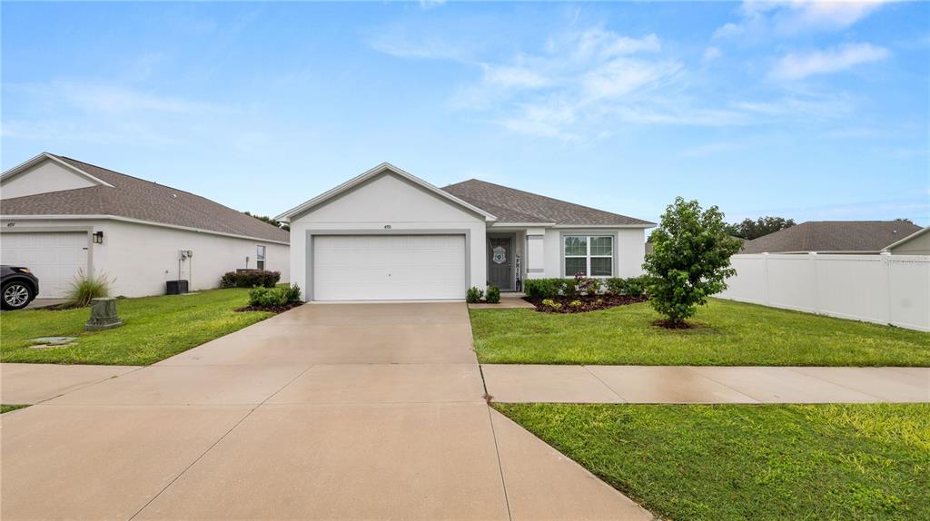 A single-story suburban house features a white exterior, a two-car garage, and a front lawn — 4791 DRAKE AVENUE, LAKELAND, FL