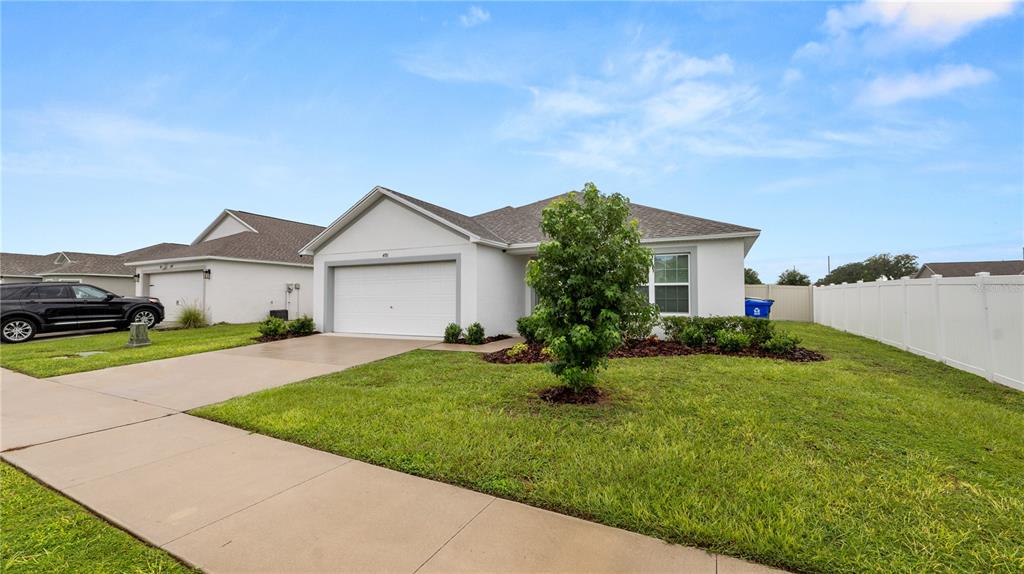 A single-story house with a white exterior, a two-car garage, and a front lawn — 4791 DRAKE AVENUE, LAKELAND, FL
