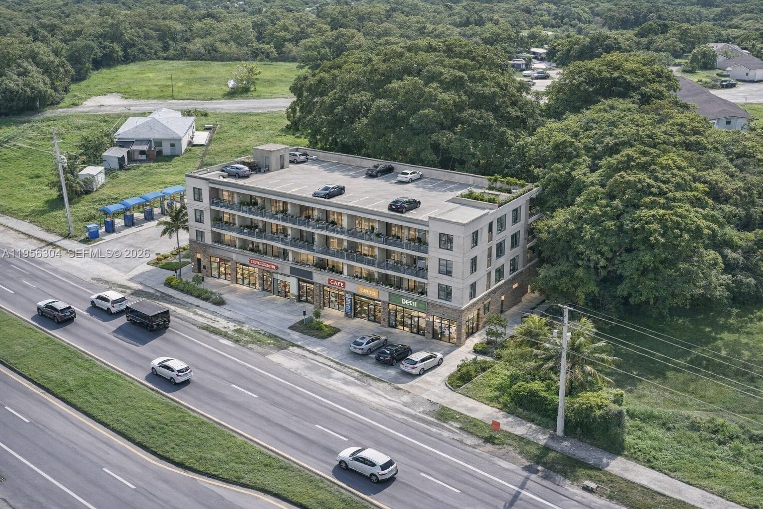 An aerial view shows a multi-story building with ground-floor retail and rooftop parking — 21855 S Dixie Hwy, Miami FL 33170, MIAMI, FL