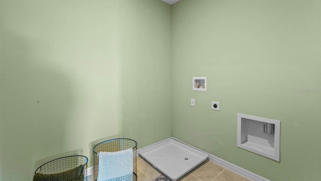 A laundry room with light green walls, a washer drain pan, and utility hookups — 2614 ANGEL FALLS DRIVE, DAVENPORT, FL